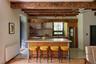 Kitchen with radiator heating unit, a kitchen breakfast bar, light countertops, stainless steel appliances, and beamed ceiling