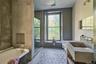 Full bath featuring a freestanding tub, vanity, light flooring, and a stall shower