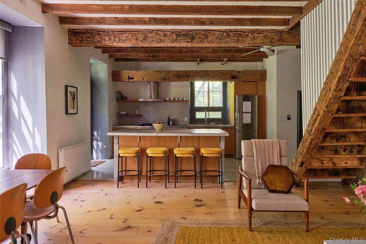 Kitchen with light countertops, radiator heating unit, open shelves, beam ceiling, and freestanding refrigerator