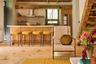 Bar area with open shelves, light countertops, wall chimney range hood, freestanding refrigerator, and light wood-type flooring