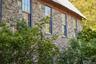 View of home's exterior with stone siding and a metal roof