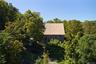 Aerial view of property and surrounding area with a forest