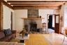 Living area with a premium fireplace, beamed ceiling, radiator, and hardwood / wood-style flooring