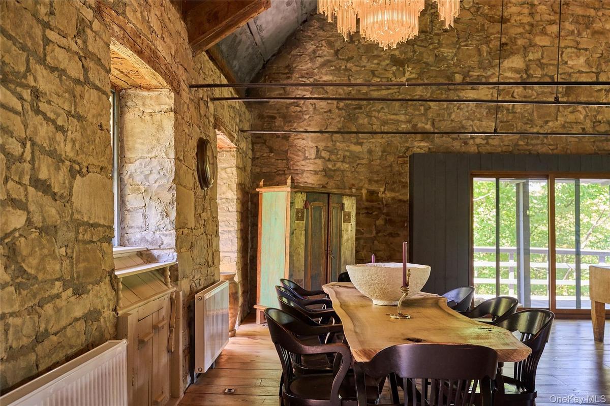 Dining space featuring radiator, hardwood / wood-style floors, a high ceiling, and a chandelier
