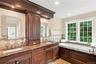 A beautifully appointed primary bathroom featuring custom cabinetry, elegant finishes, and thoughtful details, creating a luxurious and relaxing retre
