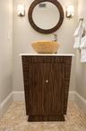 An exquisitely designed powder room featuring a striking honey and white onyx vessel sink, custom wood vanity, and elegant finishes that reflect the h