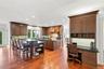 A beautifully designed gourmet kitchen featuring custom cherry cabinetry, dual islands with breakfast bar seating, rich hardwood floors, and a built-i