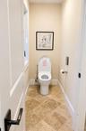 A modern bidet located in a private, enclosed space within the primary bathroom, offering added comfort and privacy.