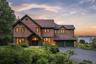 A striking Colonial residence framed by lush landscaping, with warm architectural lighting and breathtaking Hudson River views creating an unforgettab