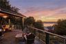 Expansive  1100 Sq foot Ipe deck with a partial covered section, featuring a ceiling fan, cable railing system, and water scenery