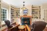 A closer look at the elegant library, featuring a beautiful fireplace with marble surround, custom wood mantel, and floor-to-ceiling built-in bookshel