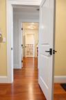 A view of the primary suite’s three custom walk-in closets, thoughtfully designed with exceptional storage and leading into the luxurious primary bath