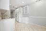 Kitchen featuring white cabinetry, stainless steel sink, tiled flooring, and built-in double ovens