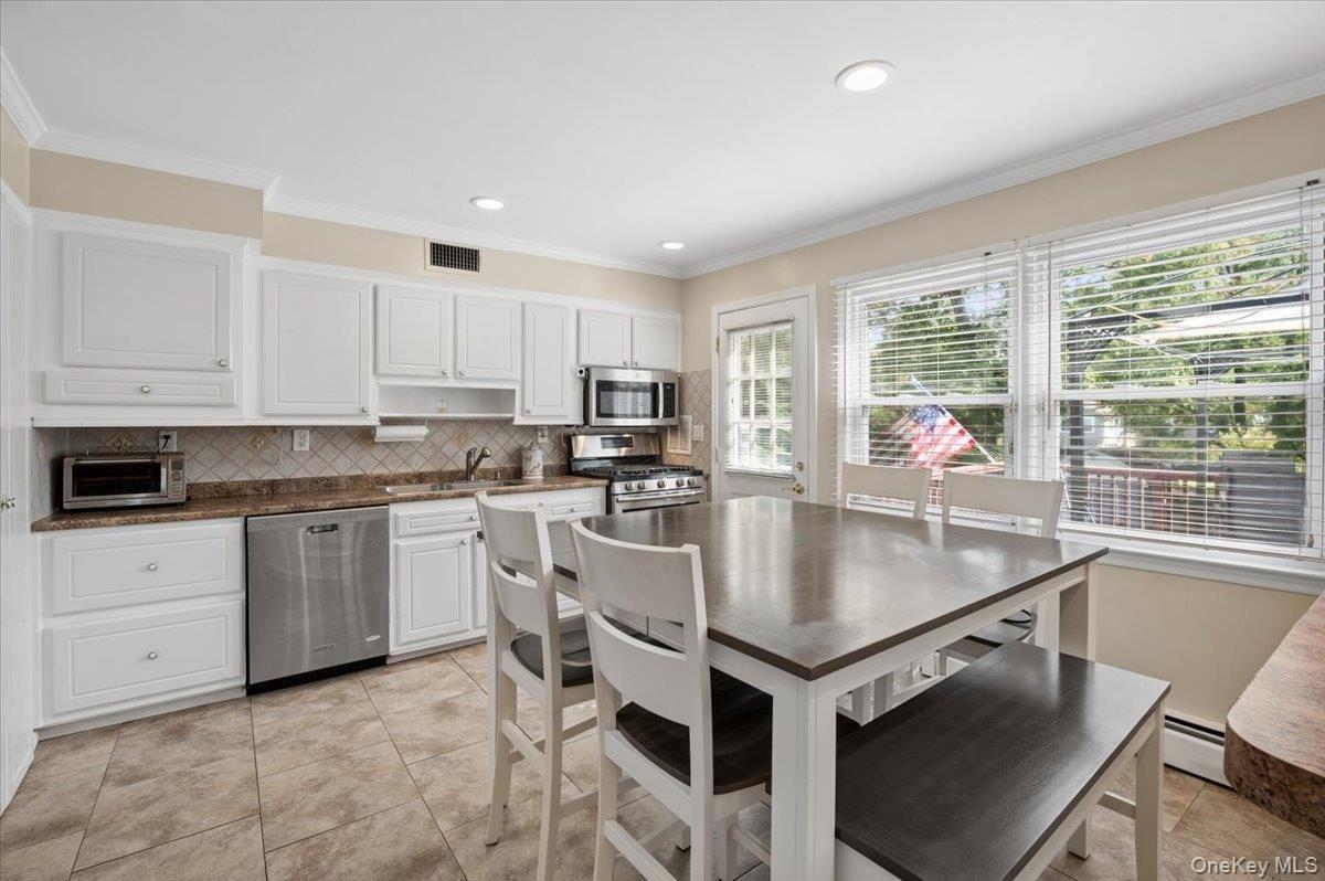 Eat-in kitchen with stainless steel appliances, breakfast bar and access to your deck.