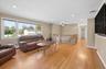 Formal living room with hardwood floors, recessed lighting, picture window and pellet stove.