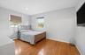Second bedroom with hardwood floors and recessed lighting.