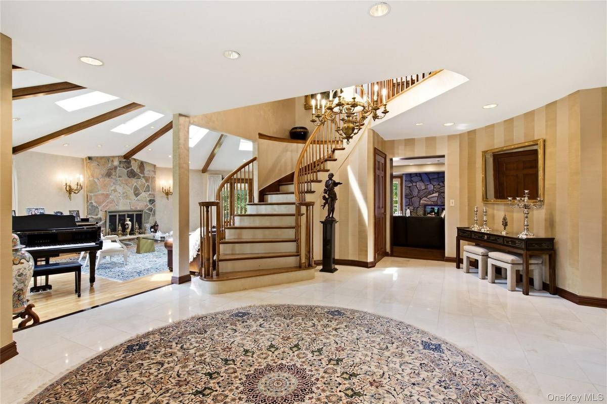 Grand entry with marble flooring, and curved staircase.
