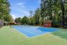 Tennis court featuring a blue playing surface, and perimeter fencing