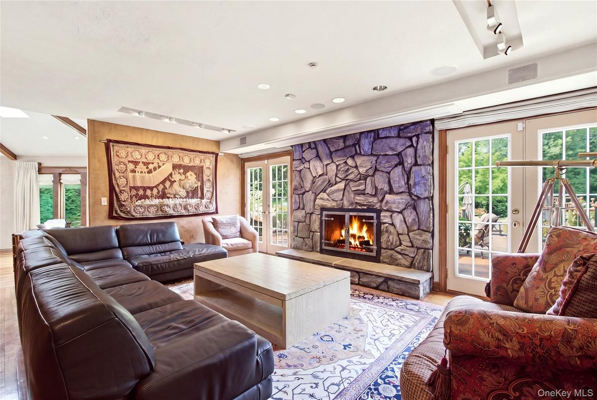 Stone-clad fireplace, wood-finish flooring, and French doors