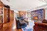 Stone fireplace with hearth, wood-finish flooring, built-in shelving, built-in cabinetry, recessed lighting