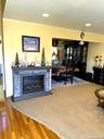 Recessed lighting, wood-finish flooring, a stone-front fireplace with a built-in electric insert, and an open concept layout