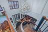 Two-story living space with a spiral staircase, a crystal chandelier, and built-in shelving