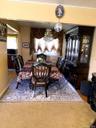 Formal dining area with chandelier lighting and wood-finish flooring