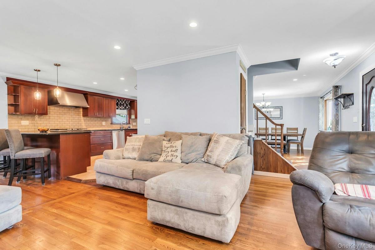 Hardwood flooring, recessed lighting, crown molding, stainless steel appliances, and a tiled kitchen backsplash
