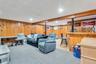 Wood paneling, recessed lighting, carpeted and wood-finish flooring, and a built-in bar