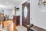 Hardwood flooring, recessed ceiling lighting, crown molding, and a decorative front entry door with an oval glass insert