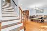 Hardwood flooring throughout, crown molding, chandelier lighting, recessed lighting, and a wood staircase with a matching banister