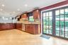 U-shaped kitchen featuring wood cabinetry, stainless steel appliances, dark countertops, a subway tile backsplash, and recessed lighting