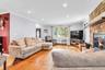 Recessed lighting, wood-finish flooring, and a stone-clad fireplace with a wood mantel