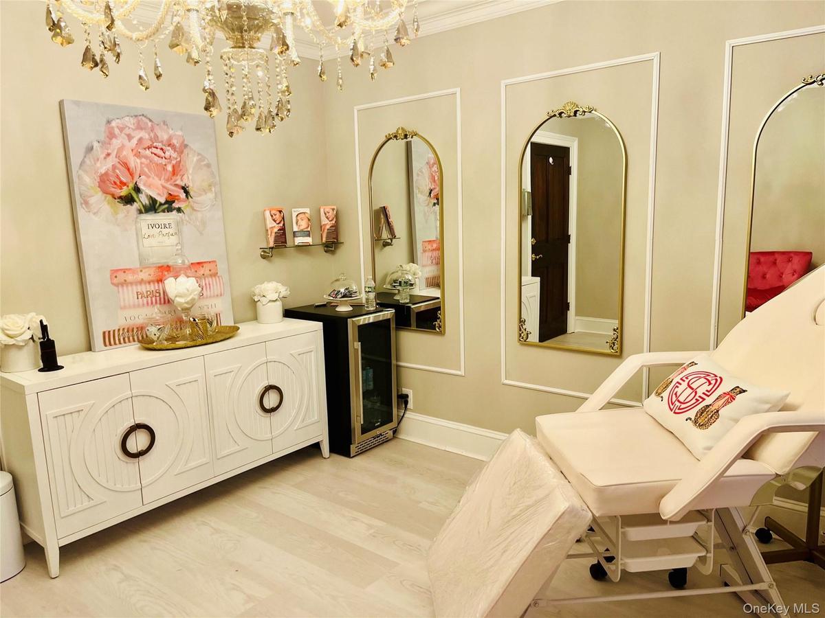 Chandelier lighting, decorative wall mirrors, built-in wall paneling, and wood-finish flooring