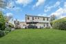 Expansive green lawn with a retaining wall, complemented by mature privacy landscaping