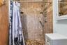Tiled shower enclosure featuring a handheld showerhead and built-in shelving