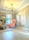 Elegant spa-inspired room featuring soaring coffered ceilings with recessed lighting, a crystal chandelier, light wood-finish flooring, and soft neutr