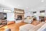 Stone-surround fireplace with hearth, wood-finish flooring, recessed lighting, crown molding, and clerestory windows