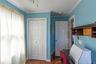 Wood-finish flooring, white bi-fold closet doors, white paneled interior door, crown molding, and built-in shelving unit