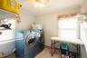 Laundry area featuring a ceiling fan, window with blinds, wall-mounted shelving, and tile flooring