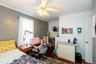 Hardwood-finish flooring, ceiling fan with integrated lighting, crown molding, and a built-in desk area
