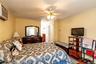 Wall-mounted air conditioning unit, ceiling fan with integrated lighting, and wood-finish flooring