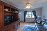 Wood-finish flooring, built-in entertainment center, bay window, ceiling fan, and crown molding