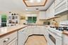 The Eat In Kitchen Offers Walls Of Cabinetry With Ample Storage, Oversized Kitchen Sink With A Large Window Above, Vast Counter/Serving Spaces & Opens