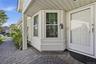 A Brick/Paver Walkway With An Accent Custom Embedded Circle At The Covered Front Entry Leads Into The Home.