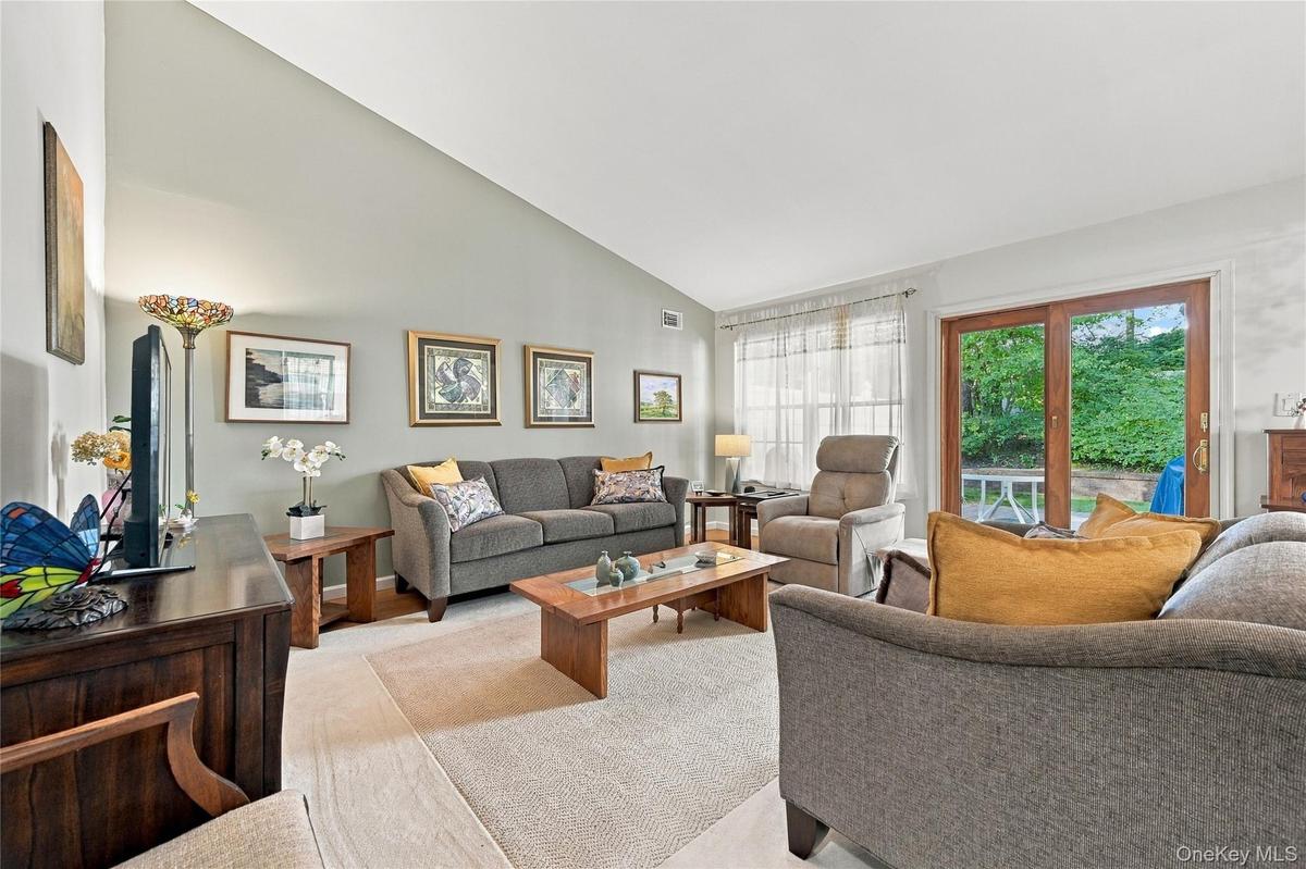 The Elegant & Inviting Formal Living Room Offers Warm Colors/Hues With An Accent Wall, Vaulted/Volume Ceilings And New Andersen Sliding Doors To A Lar