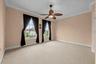 A spacious bedroom with soft natural light, crown molding, and room to make it your own-with walk-in closet