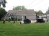 Expansive backyard featuring a manicured lawn, concrete patio, and a built-in pergola structure