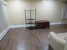 Wood-finish flooring with white baseboards, cream-colored walls, and recessed lighting