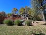 Expansive rear yard with a tiered wood-plank deck, stone-stepped pathway, and 4-Season Room